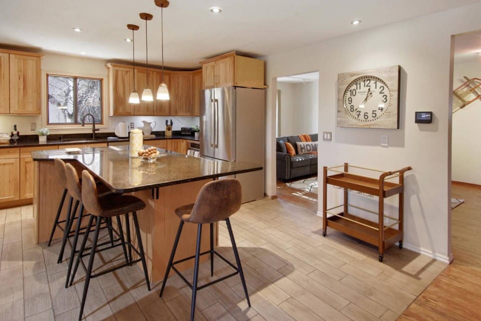 Bar stools, spacious kitchen, rolling rack make this kitchen useful and versatile