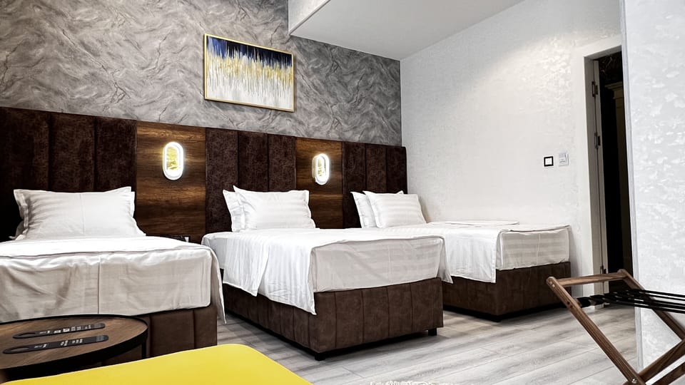 Deluxe Triple Room | Minibar, in-room safe, desk, blackout drapes