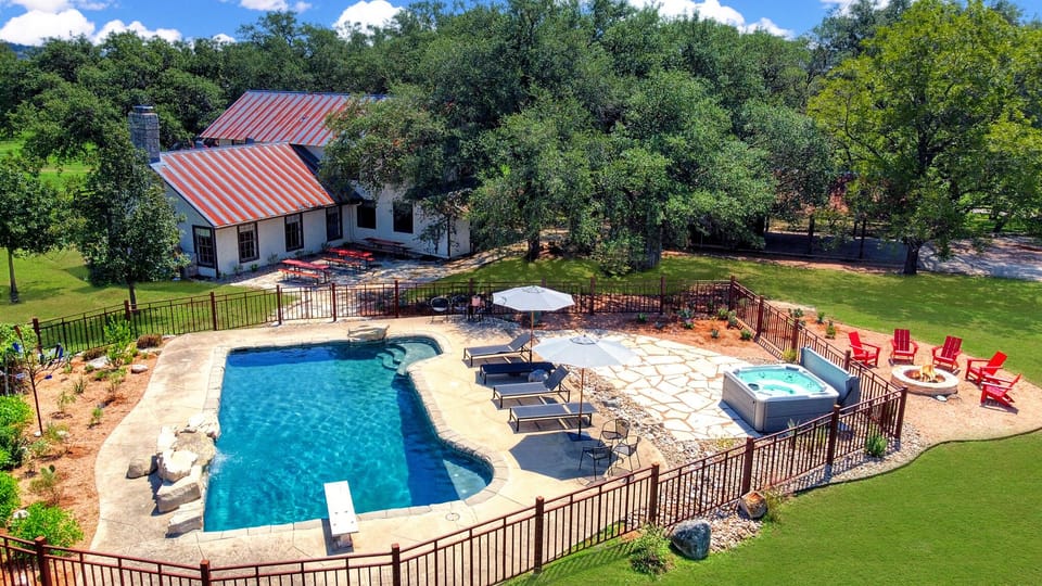 Aerial view of the rear of the main house with pool and hot tub.