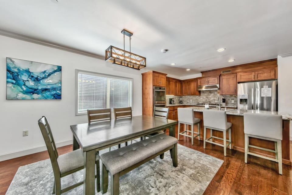 Gather around this elegant dining space where rich hardwood floors meet warm cherry cabinets, creating the perfect backdrop for memorable meals.