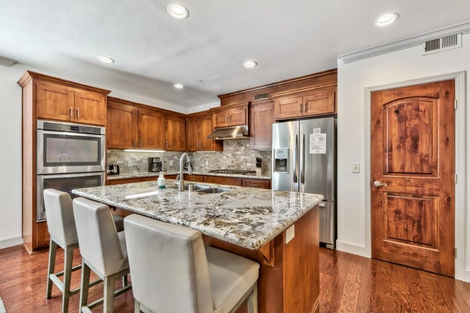 Your gourmet kitchen awaits with rich wood cabinetry, granite island, and stainless steel appliances perfect for creating memorable meals.