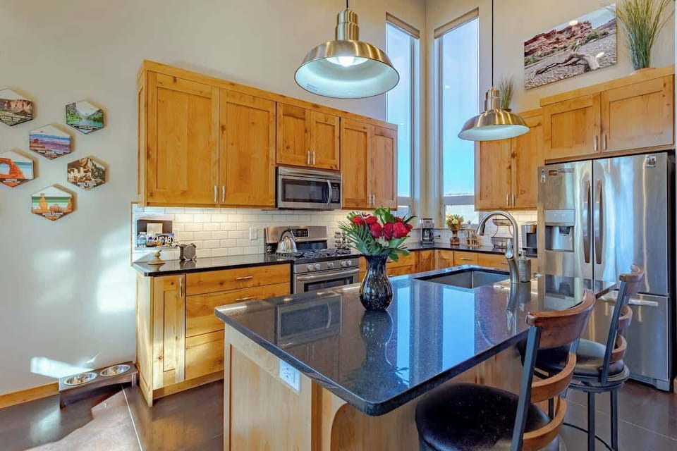 Fully-equipped Kitchen with island sink, and stainless steel appliances: gas range/oven, microwave, fridge with ice and water in the door