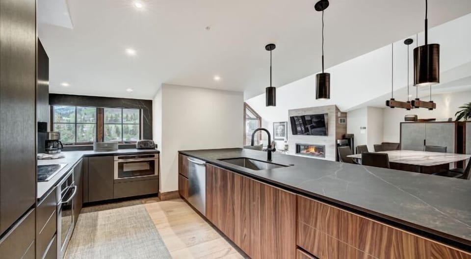 This sleek kitchen not only boasts cutting-edge appliances but also breathtaking views of the majestic mountains through large windows.
