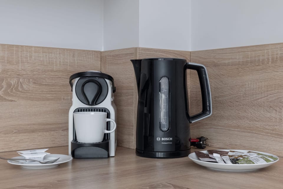 A coffee and tea corner with a kettle, cups, and a modern design for a welcoming touch.
