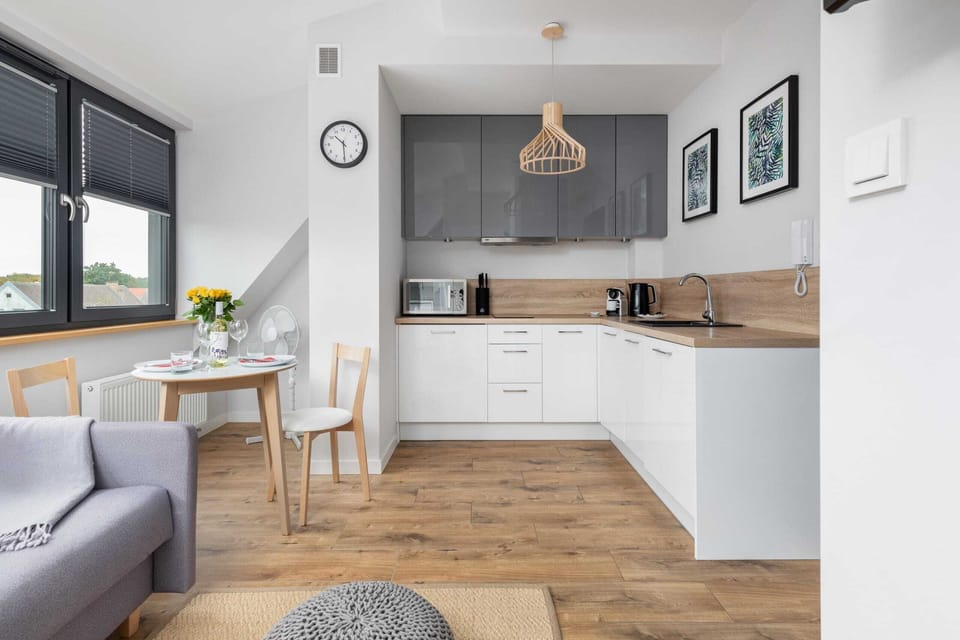 A bright open-plan kitchen and dining space with elegant furnishings and wooden floors.
