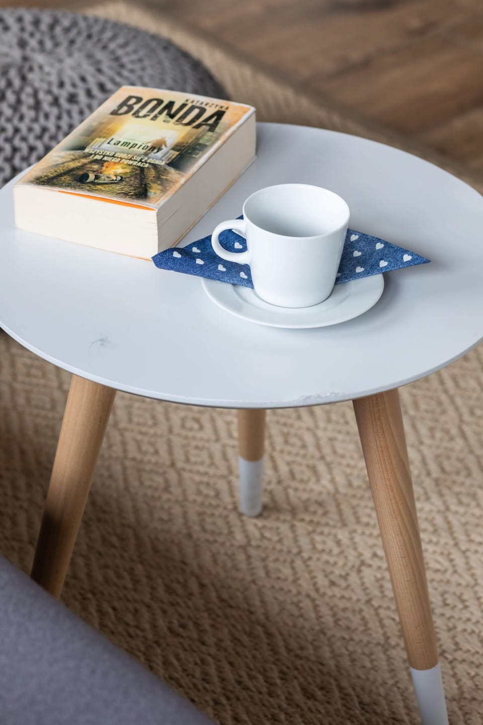 A cozy coffee table setup with a book and cup, offering a relaxing spot for a quiet moment.
