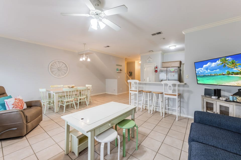 Relax in your bright, open living space with coastal touches and tropical scenes on the large TV to set your vacation mood.