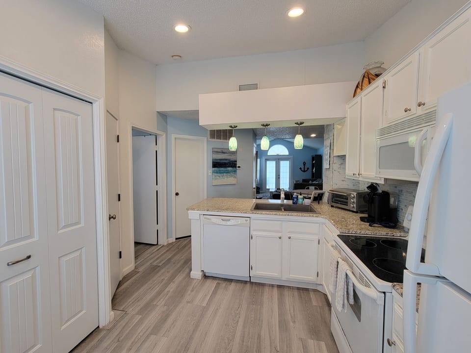 Double doors in kitchen lead to washer and dryer