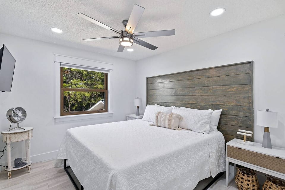 Inviting bedroom w/ ceiling fan and warm accent wall.