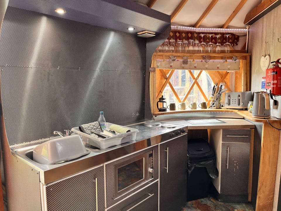Kitchenette with hob, microwave, kettle, toaster, small dishwasher and fridge with freezer compartment