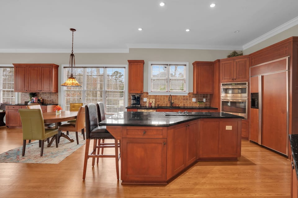 Main kitchen with warm-toned kitchen, large island and storage