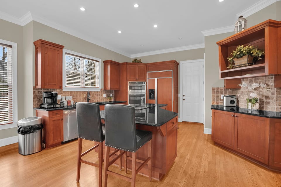 Main kitchen with bar seating and warm cabinetry