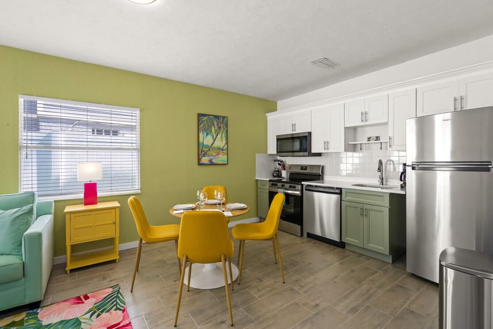 Siesta Key Beach dining area with yellow chairs, tropical art, and cozy setup for shared meals and lasting memories