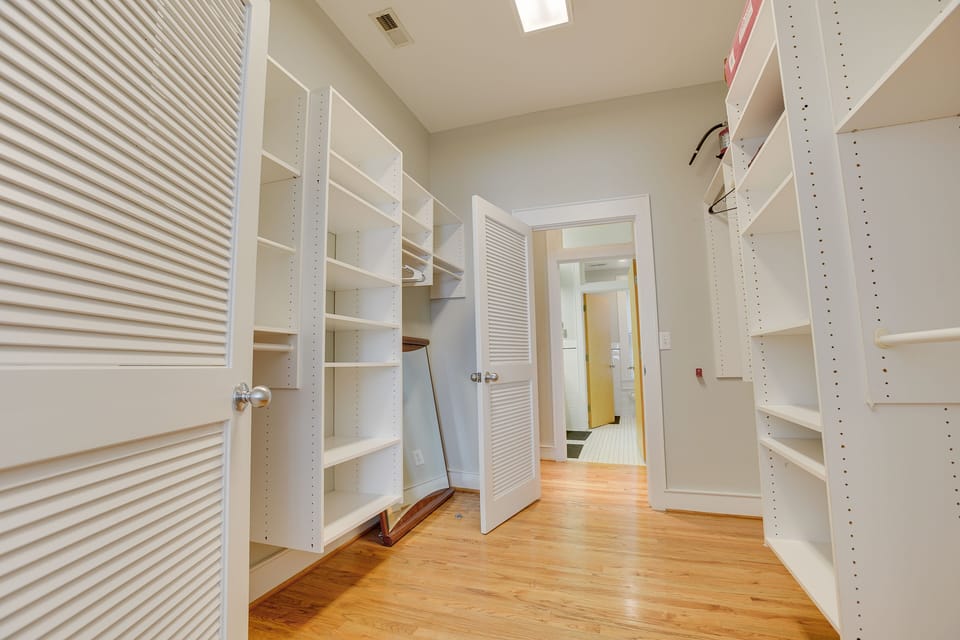 Hang up and organize your clothes with ease in this huge walk-in closet!
