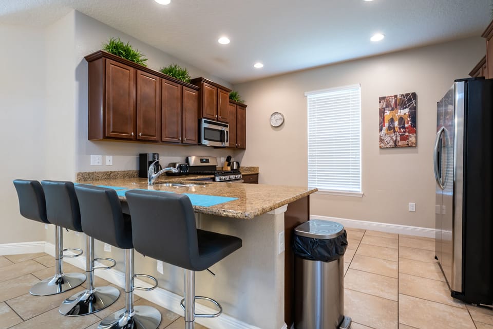 Fully equipped kitchen showing breakfast bar seating for 4