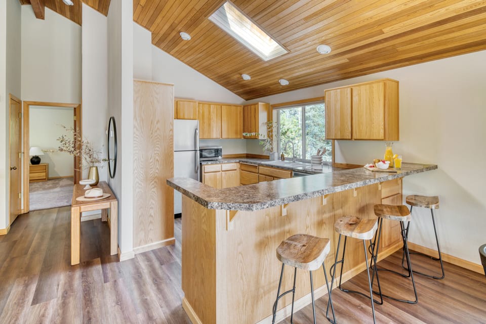 Bright kitchen features barstool seating.