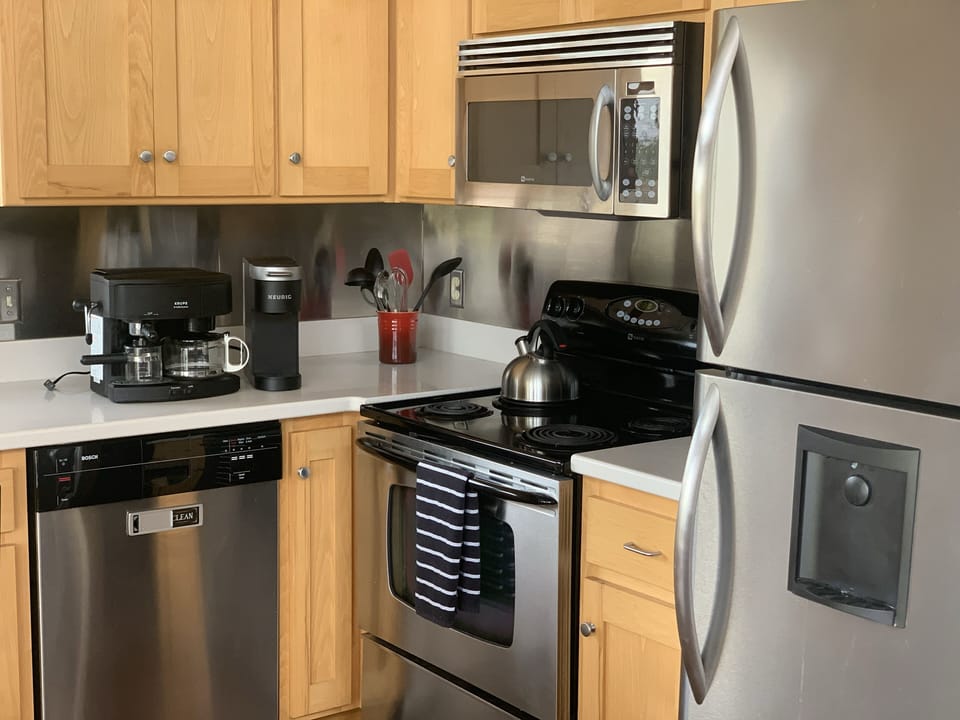 Upper level kitchen with coffee makers, range, microwave and full size fridge