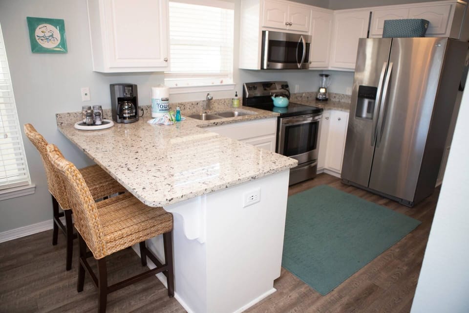 Breakfast bar and modern updated kitchen with stainless steel appliances