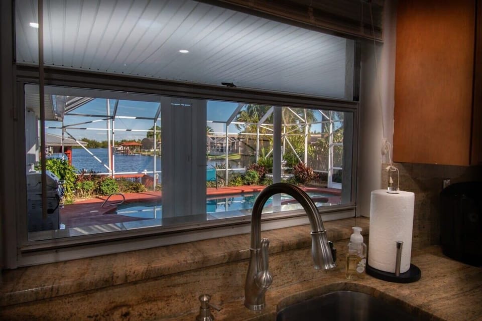 View of the screened pool and waterfront from the kitchen sink.