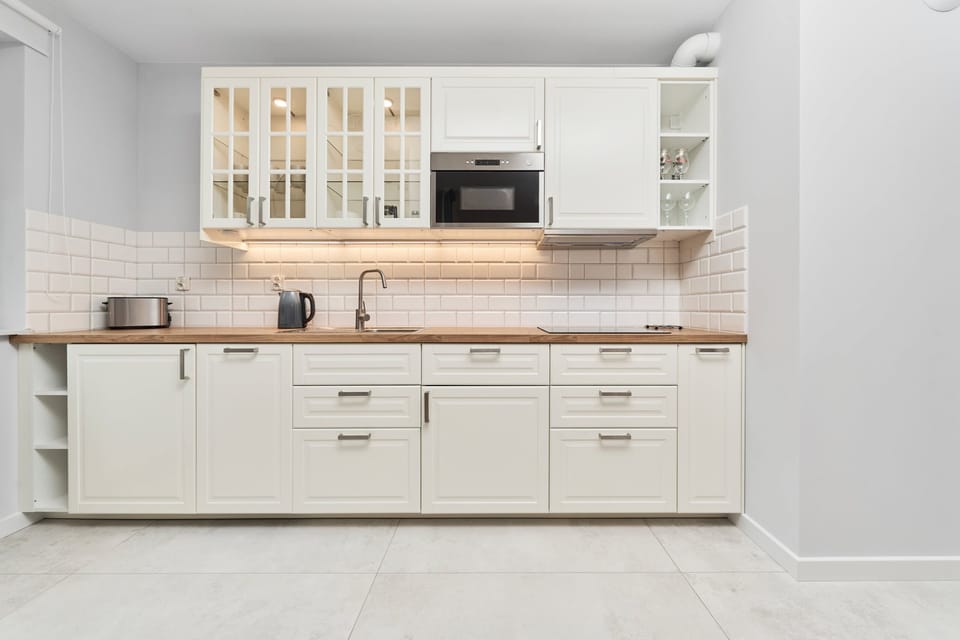 Upper view of the kitchen showing practical cabinetry, microwave, and natural wood finishes for convenient cooking.


