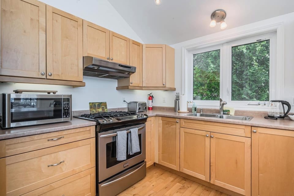 A fully stocked kitchen with gas stove, coffee maker, and microwave.