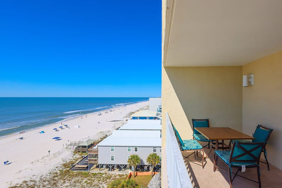 Enjoy a relaxing view from the balcony with a dining set, overlooking the sandy beach and inviting waters