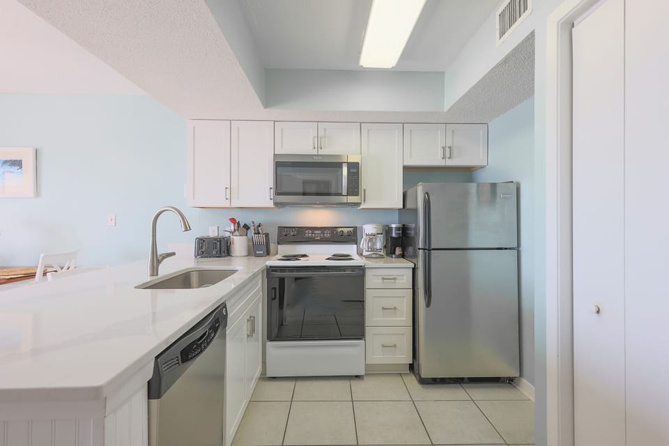This kitchen features sleek modern appliances, granite countertops, and a bright, airy atmosphere perfect for meal prep