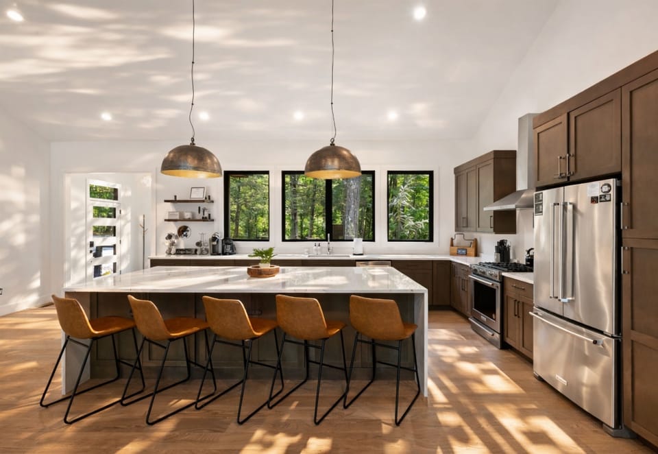 The spacious kitchen island includes plenty of seating, perfect for gathering while enjoying the natural light from the surrounding windows.