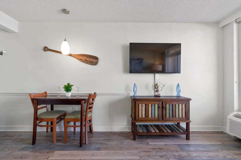 Enjoy meals or movie nights in this cozy dining and living area, featuring a coastal-inspired design, flat-screen TV, and charming beach décor that perfectly blends comfort with seaside charm.