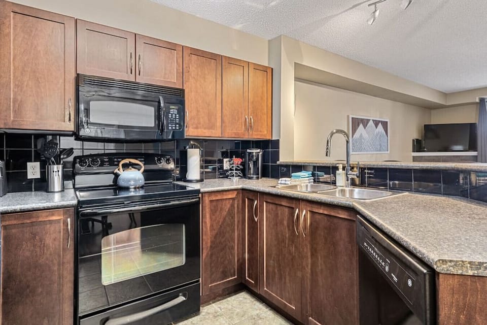 Full kitchen with a drip coffee machine, ground coffee, tea, sugar, and basic condiments (ketchup, mustard, relish.)