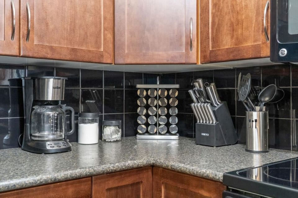 Full kitchen with a drip coffee machine, ground coffee, tea, sugar, and basic condiments (ketchup, mustard, relish.)