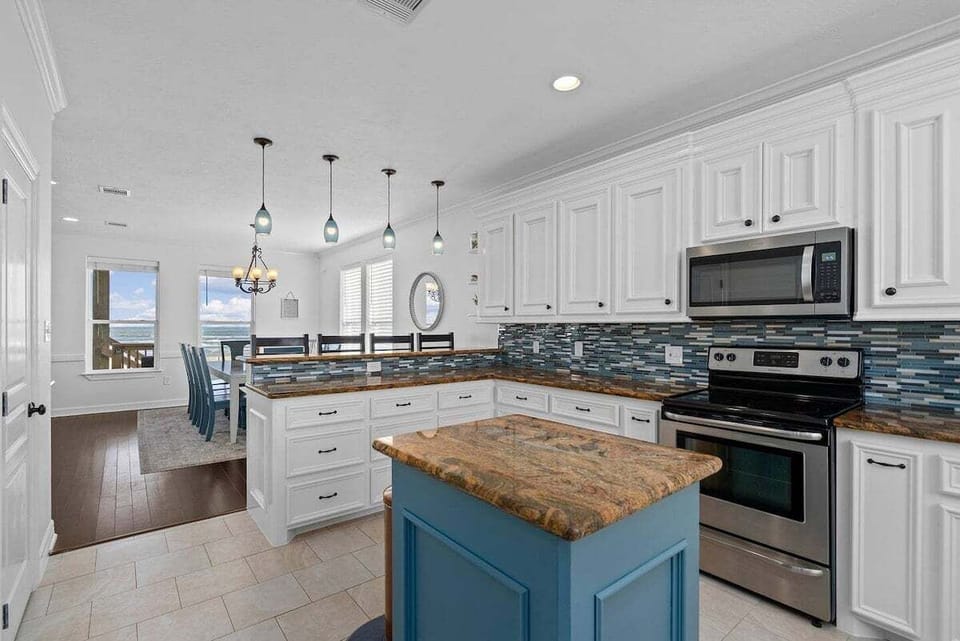 Spacious gourmet kitchen featuring stainless steel appliances, ample counter space, and large center island for entertaining guests.