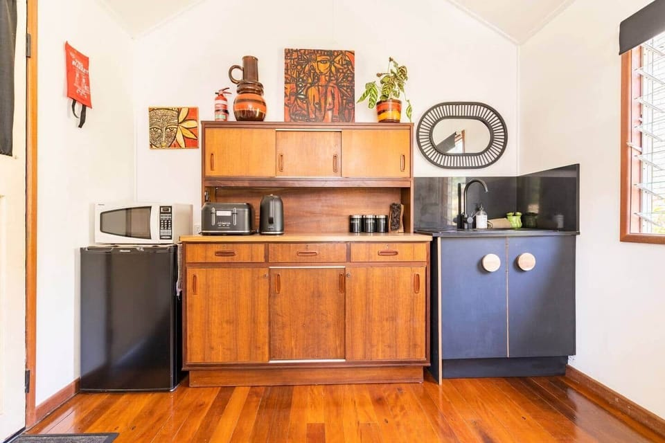 Kitchenette with hutch, bar fridge, microwave, toaster, kettle, sink.  Induction plate, banquet pan, pots, pans, salad bowls etc in the cupboards below. Plates, bowls, side plates, cups, glassware, coffee plunger and cutlery. 