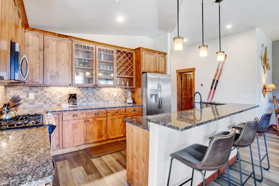 Kitchen With Custom Granite Countertops, Cabinetry, And Lighting