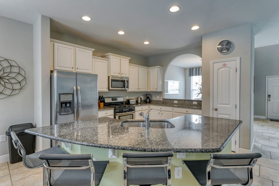 Fully equipped kitchen showing breakfast bar with seating for 4