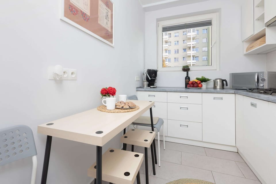 A well-organized kitchen with white cabinets, sleek countertops, and modern appliances, including a built-in oven.