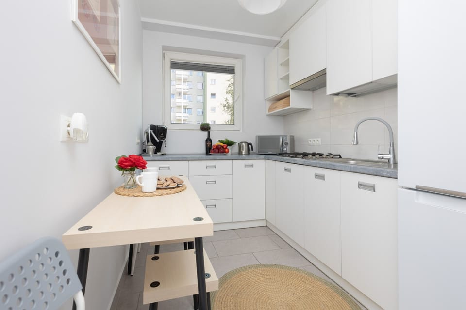 A well-organized kitchen with white cabinets, sleek countertops, and modern appliances, including a built-in oven.