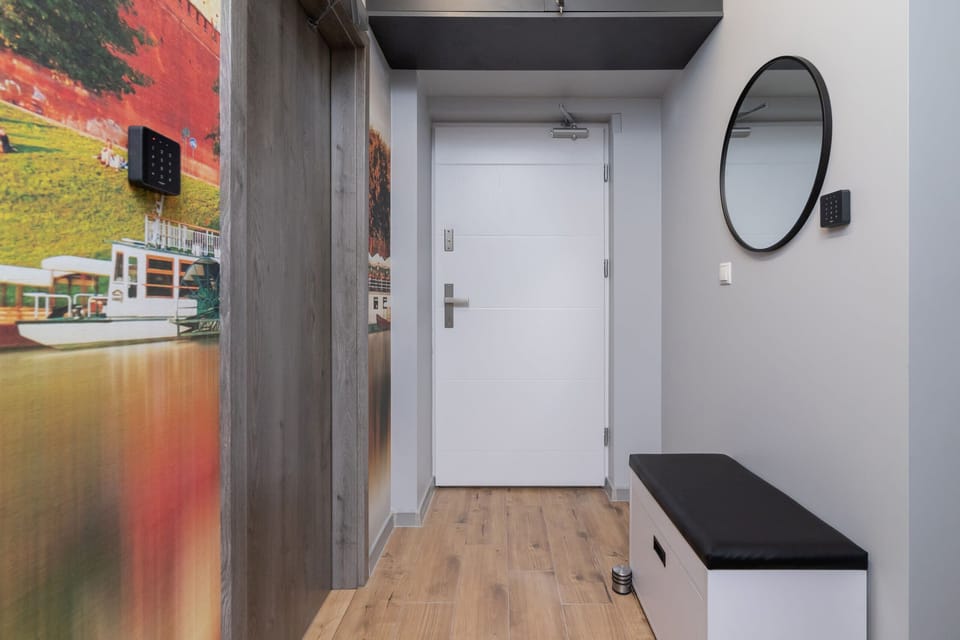 An entryway with a washing machine, storage, and stylish wall art, blending functionality and aesthetics.
