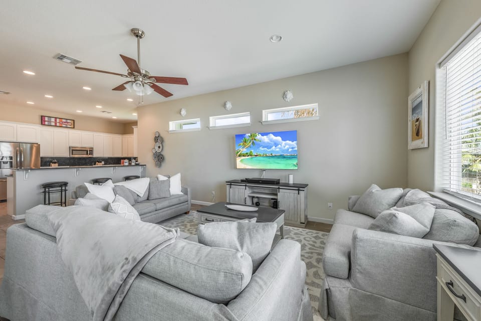 Sink into plush gray sofas and enjoy movie nights on the large screen TV in this bright, open living space.