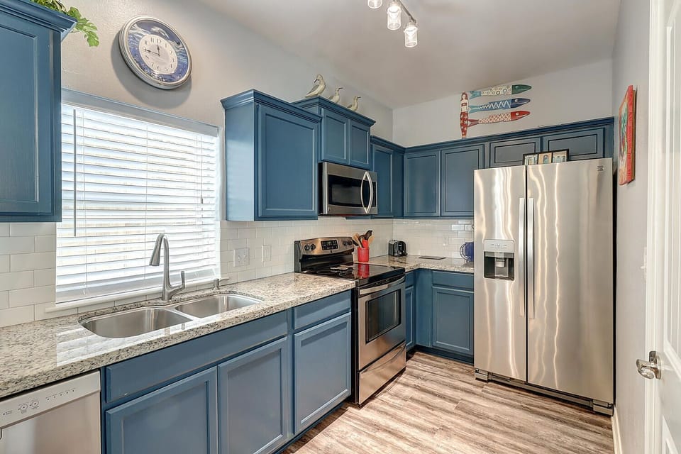 Your fully equipped kitchen features stunning blue cabinets, granite countertops, and stainless steel appliances—perfect for preparing meals during your stay.