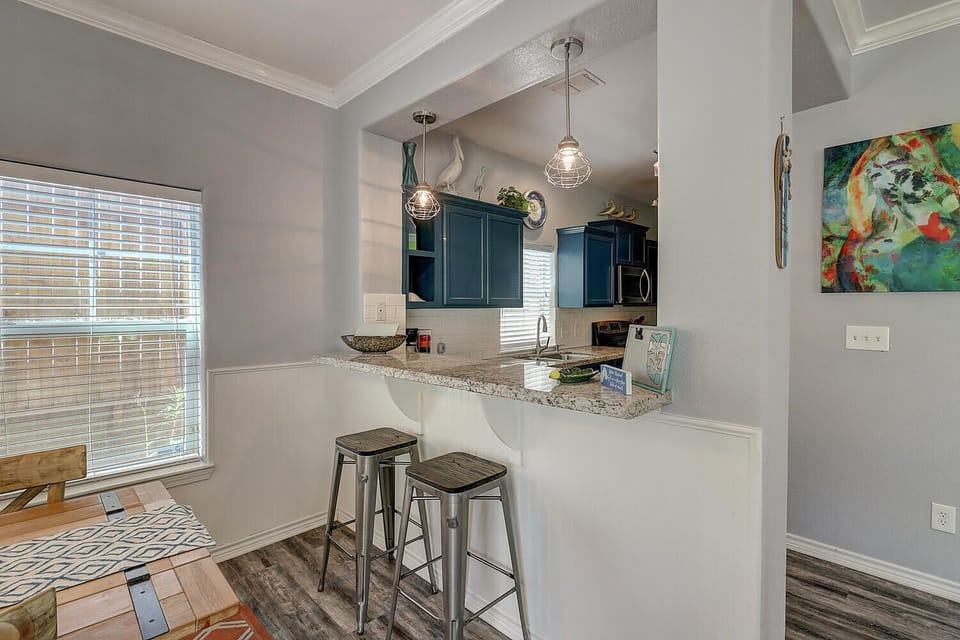 Your modern kitchen features granite countertops, stylish blue cabinets, and a breakfast bar where you can enjoy morning coffee.