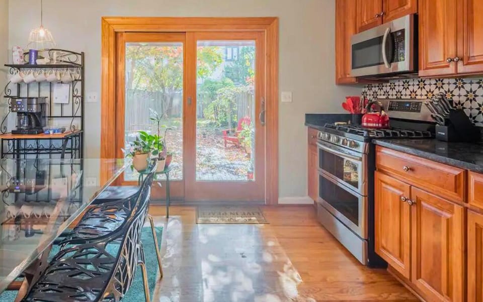Enjoy cooking in this well-lit kitchen equipped with modern appliances, ample counter space, and a scenic view of the backyard.