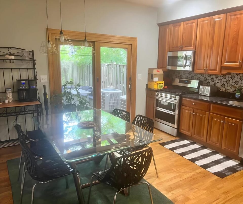 Dine in style in this inviting kitchen, featuring a sleek glass table, modern appliances, and easy access to the backyard.
