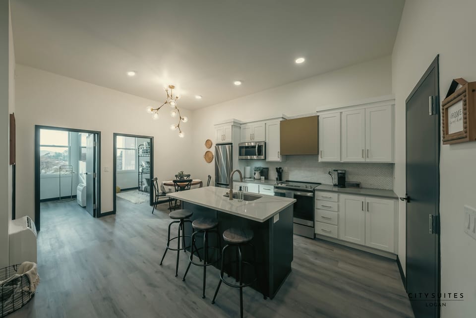 A large island anchors the full kitchen, stocked with cookware.