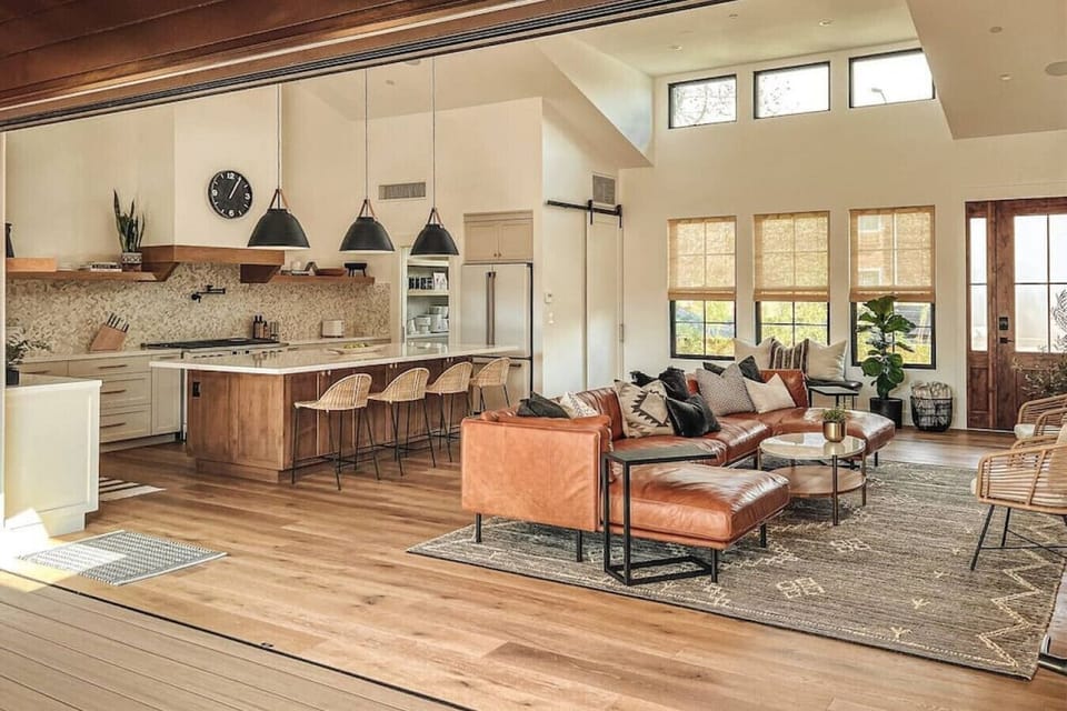 This massive 18` door opens the Great Room to the back deck, where you`ll find an outdoor living room with TV and fire table, hot tub + sun loungers with umbrella, BBQ/grill, and dining table for 8.  Beyond that you`ll find grass and a play area!