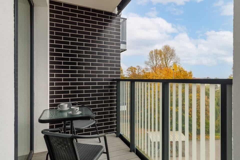 A private balcony with outdoor seating, offering a peaceful view of the surrounding area.
