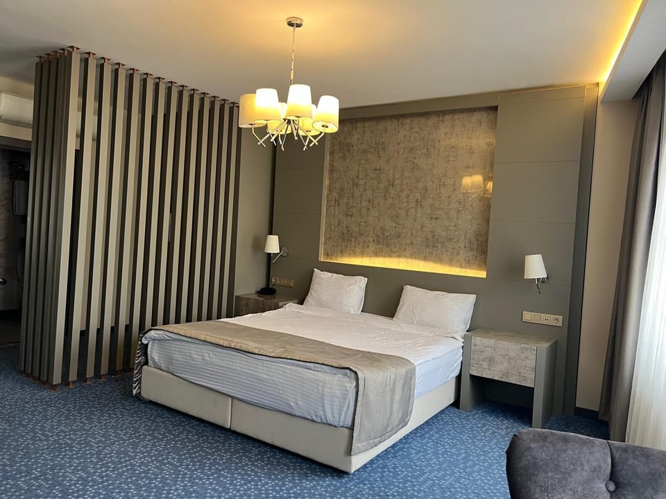 Deluxe Room | Minibar, in-room safe, blackout drapes, iron/ironing board