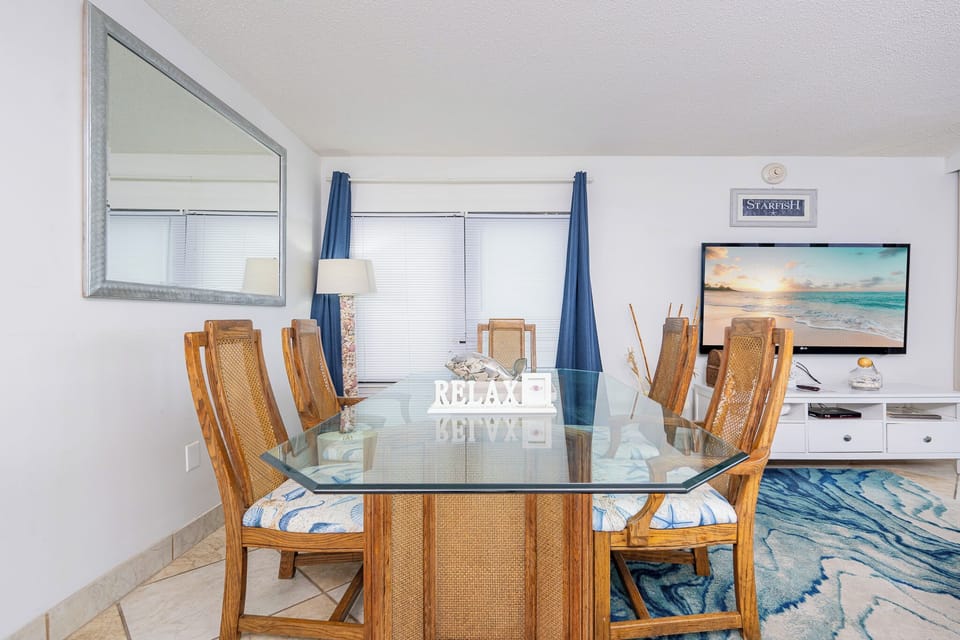 Gather around the glass table to share laughter and stories while enjoying the coastal vibe from your spacious living area
