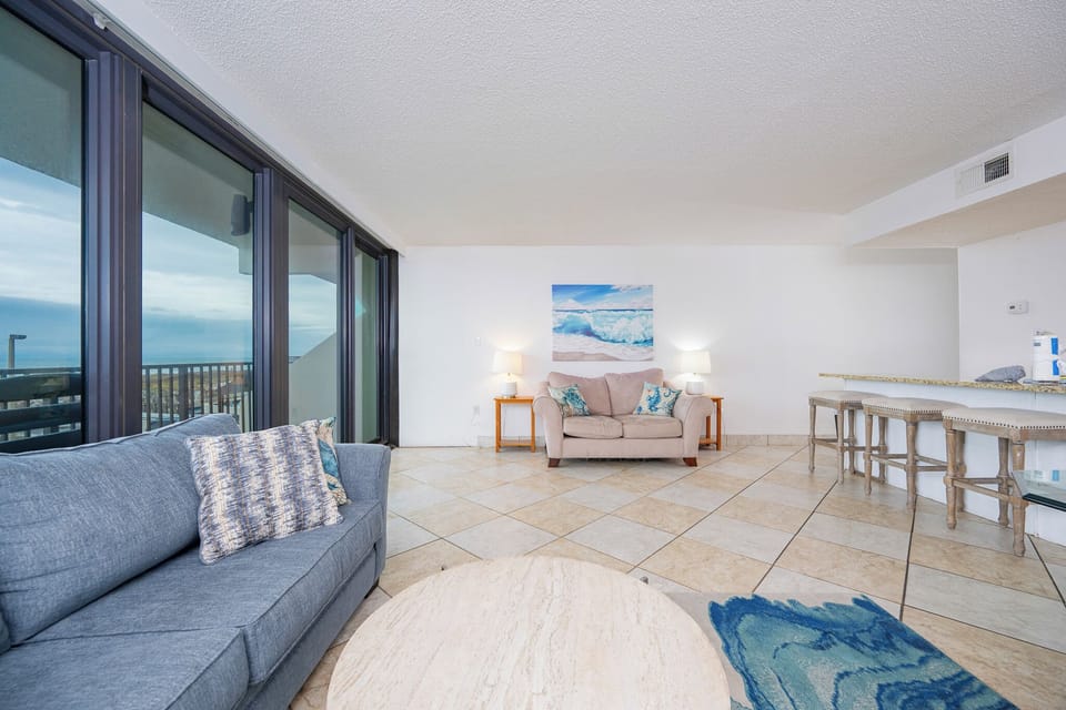 Relax on the plush sofas while enjoying the inviting vibe and breathtaking coast view through the expansive windows