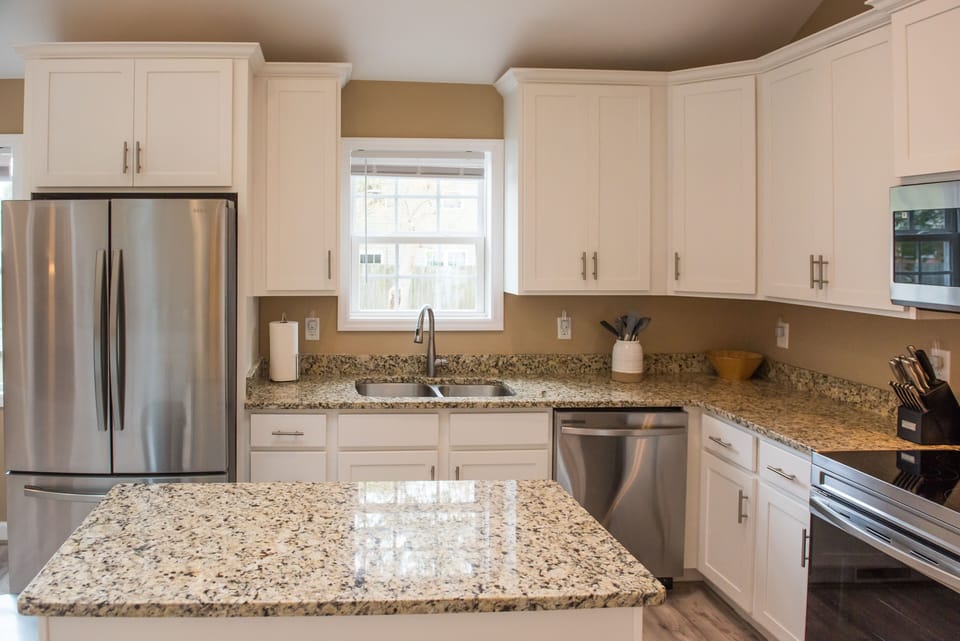 Fully stocked kitchen with stainless steel appliances and tons of natural light.